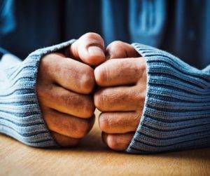 close up of hands keeping warm with a wooly jumper on