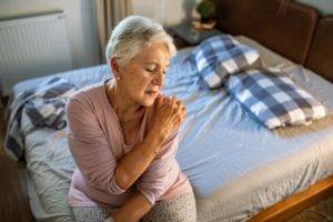 Woman with arthritis holding her shoulder