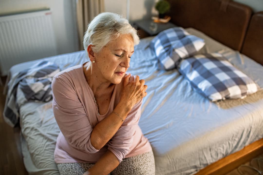 Woman with arthritis holding her shoulder